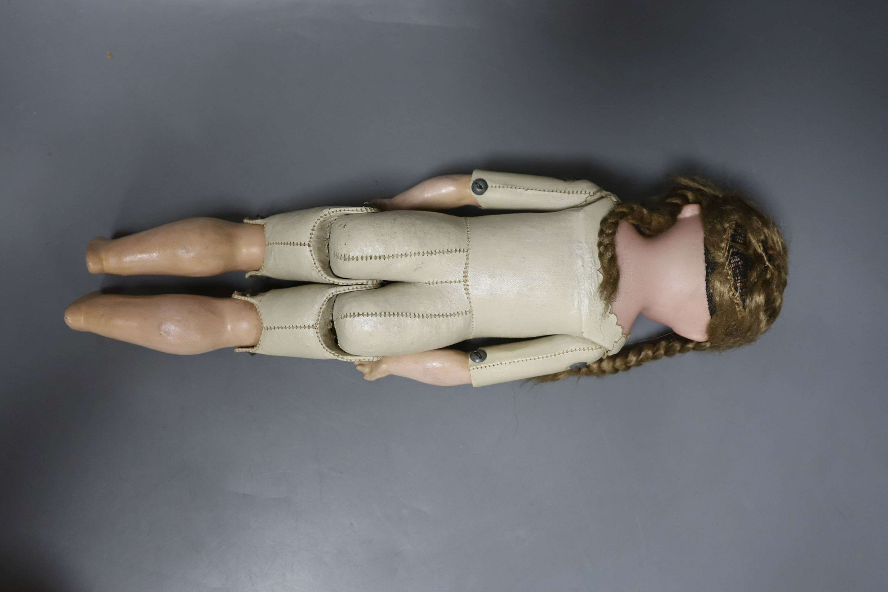 A kid leather bodied jointed limb open mouth Heubach bisque headed doll together with two other bisque headed dolls and a boy doll (damaged)